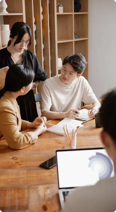 Group of coworkers in a meeting, discussing around a table