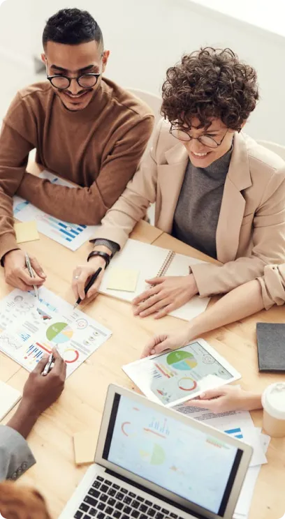 Team collaborating over charts and documents in a meeting room